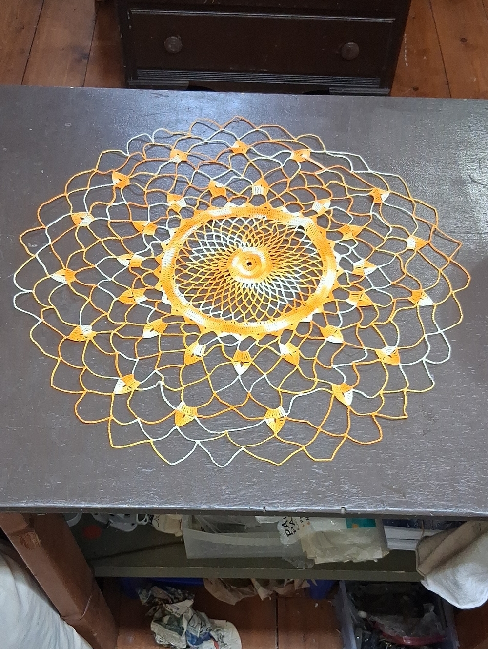 Hand crocheted yellow, orange, and white mandala design crochet doily
